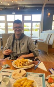 resident sitting at table with plate of food