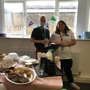 resident and team member in front of buffet spread