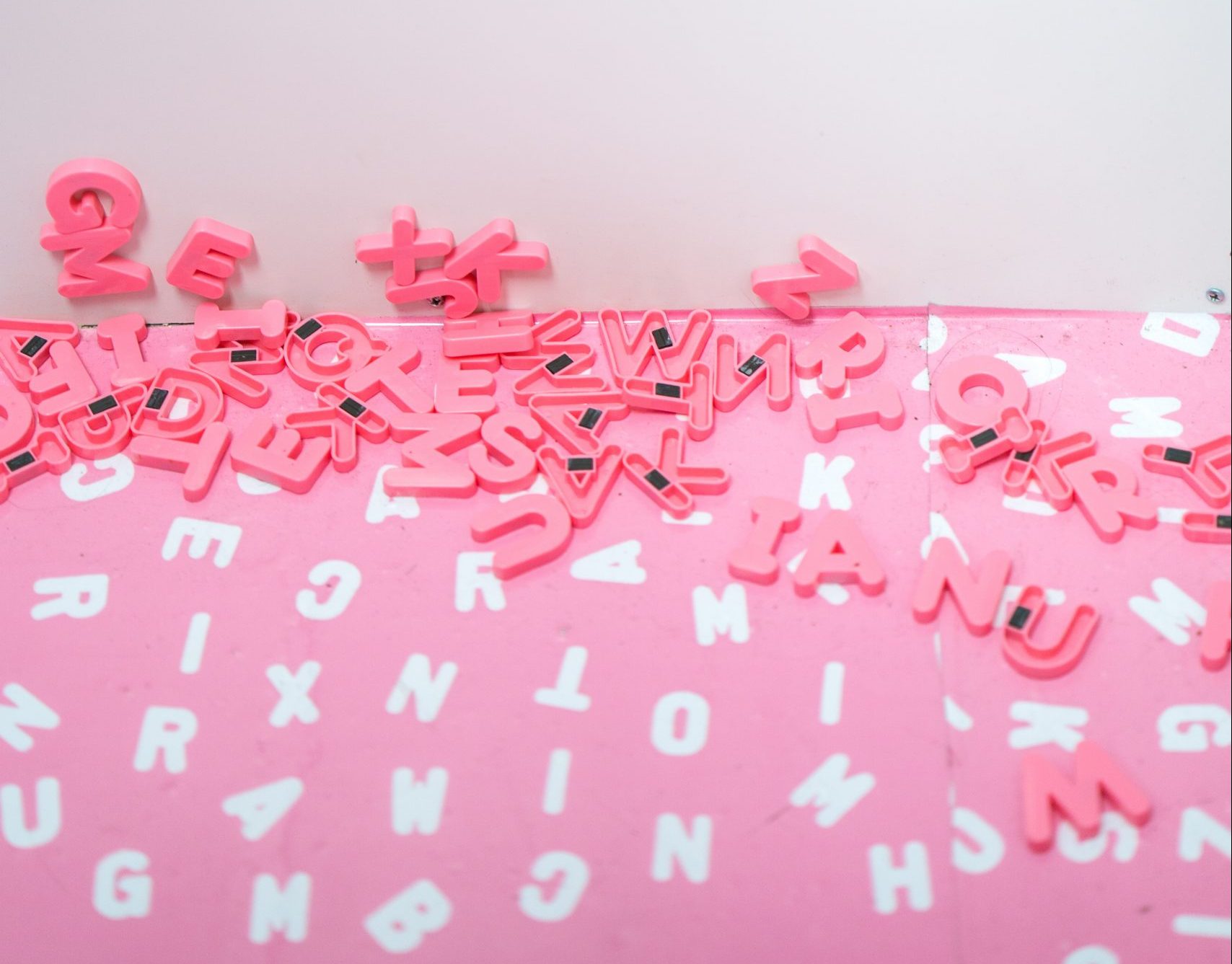 scatter of pink alphabet fridge magnets