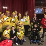 residents and team members backstage wearing yellow Pudsey bear tshirts