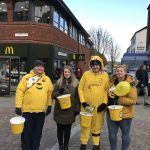 residents and team members dressed in Yellow holding Children in Need collection buckets