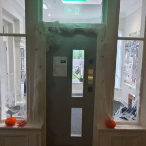 Radcliffe House Halloween decorations: door frame surrounded by pumpkins and fake cobwebs