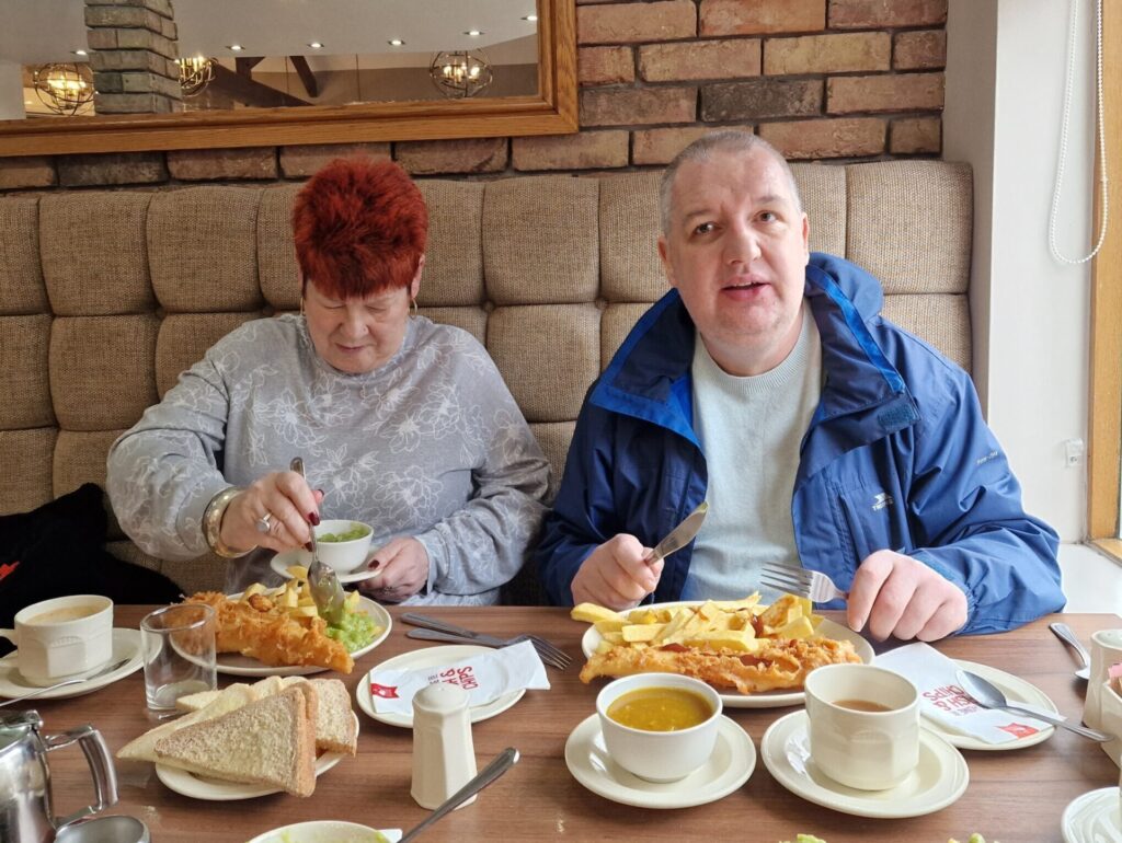 female and male resident enjoying fish and chips