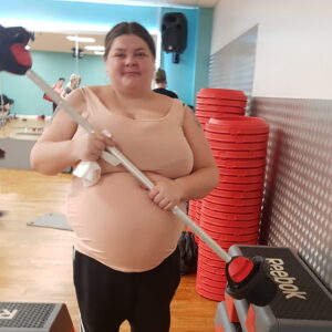 female resident holding barbell in gym