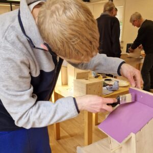 painting the roof of the wooden bird box purple