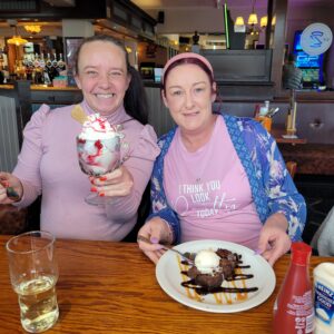 two females posing with ice cream sundae and waffles