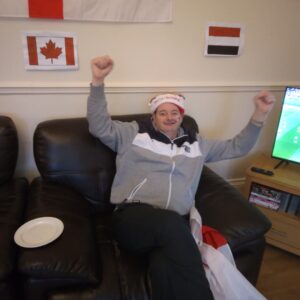 Resident cheering on England while wearing red and white hat