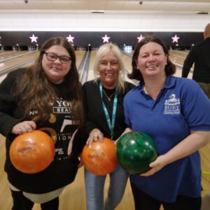 residents and team member holding bowling balls posing together
