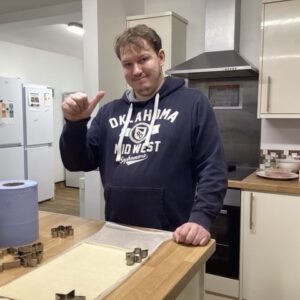 resident with pastry rolled out on kitchentop