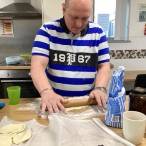 resident rolling out pastry