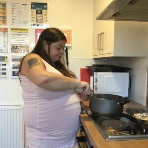 resident stirring ingredients in pan on stove