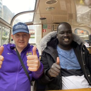Two residents giving thumbs up on a boat