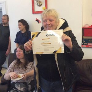 resident posing with certificate