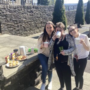 team members enjoying tea and biscuits outdoors