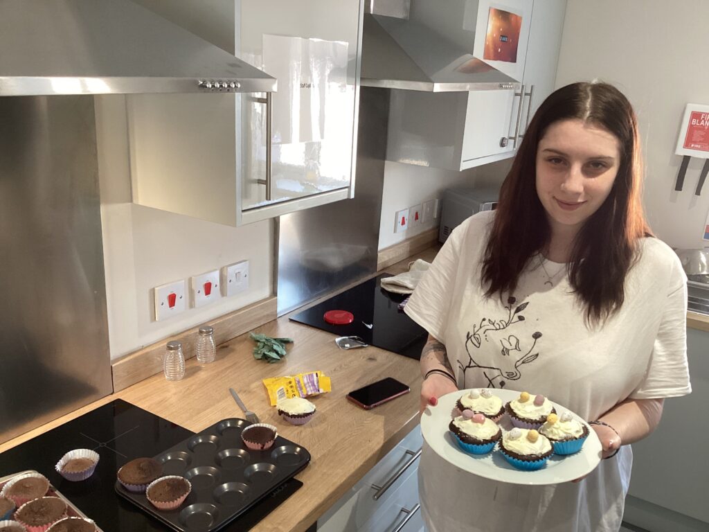 female holding plate of homemade cupcakes