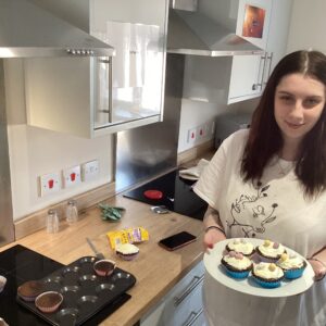 female holding plate of homemade cupcakes