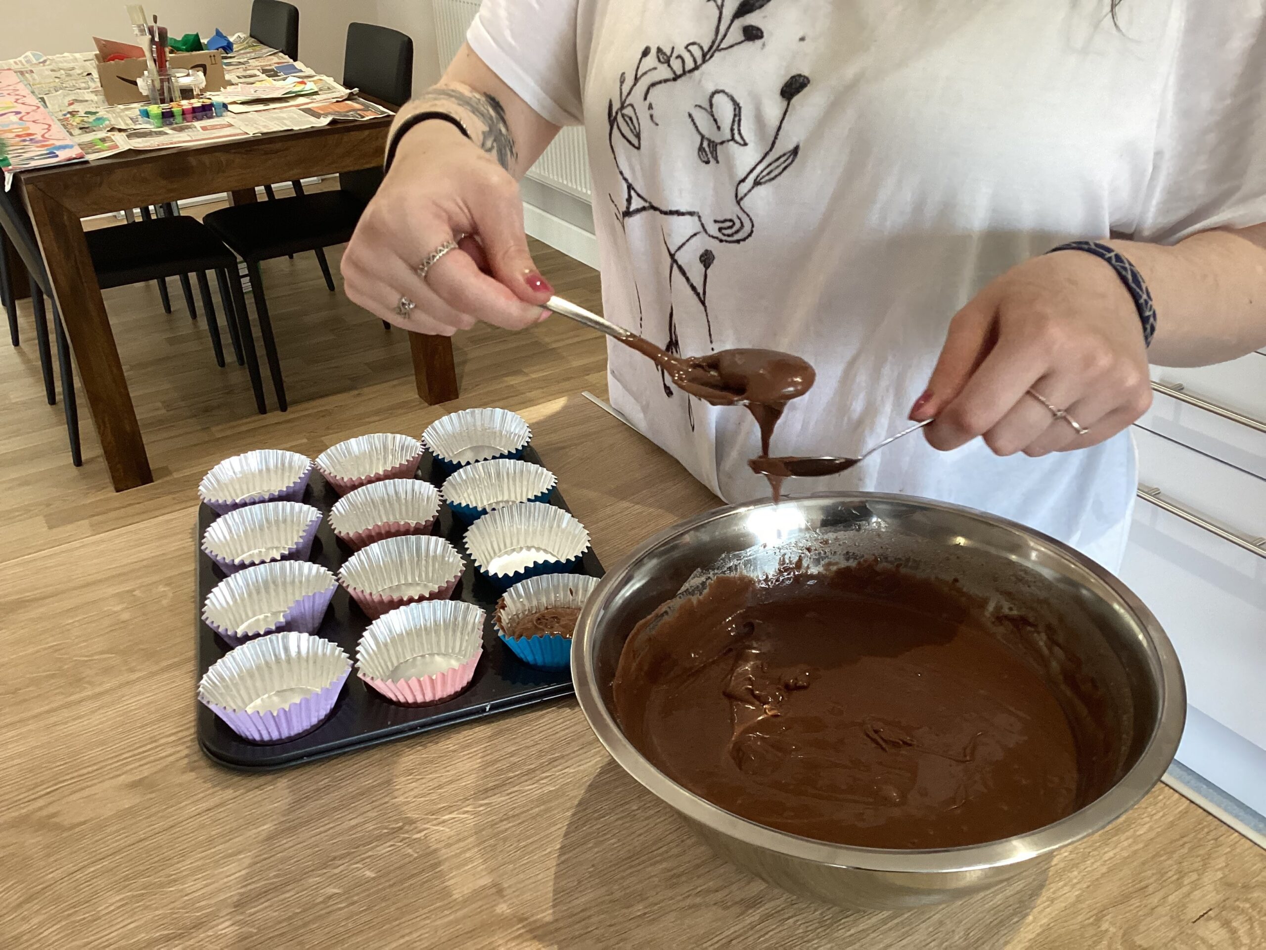 spooning cupcake mixture into cases