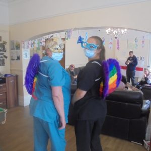 team members with rainbow wings and eye masks