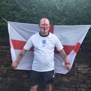 Life at Glen Garth: resident stood in front of england flag wearing england top and england flag painted on face