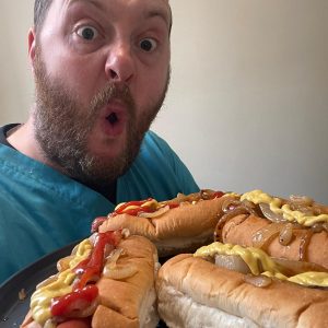 team member with plate of hotdogs