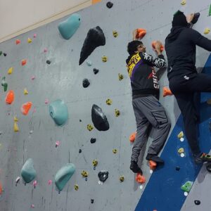 residents and team members on climbing wall