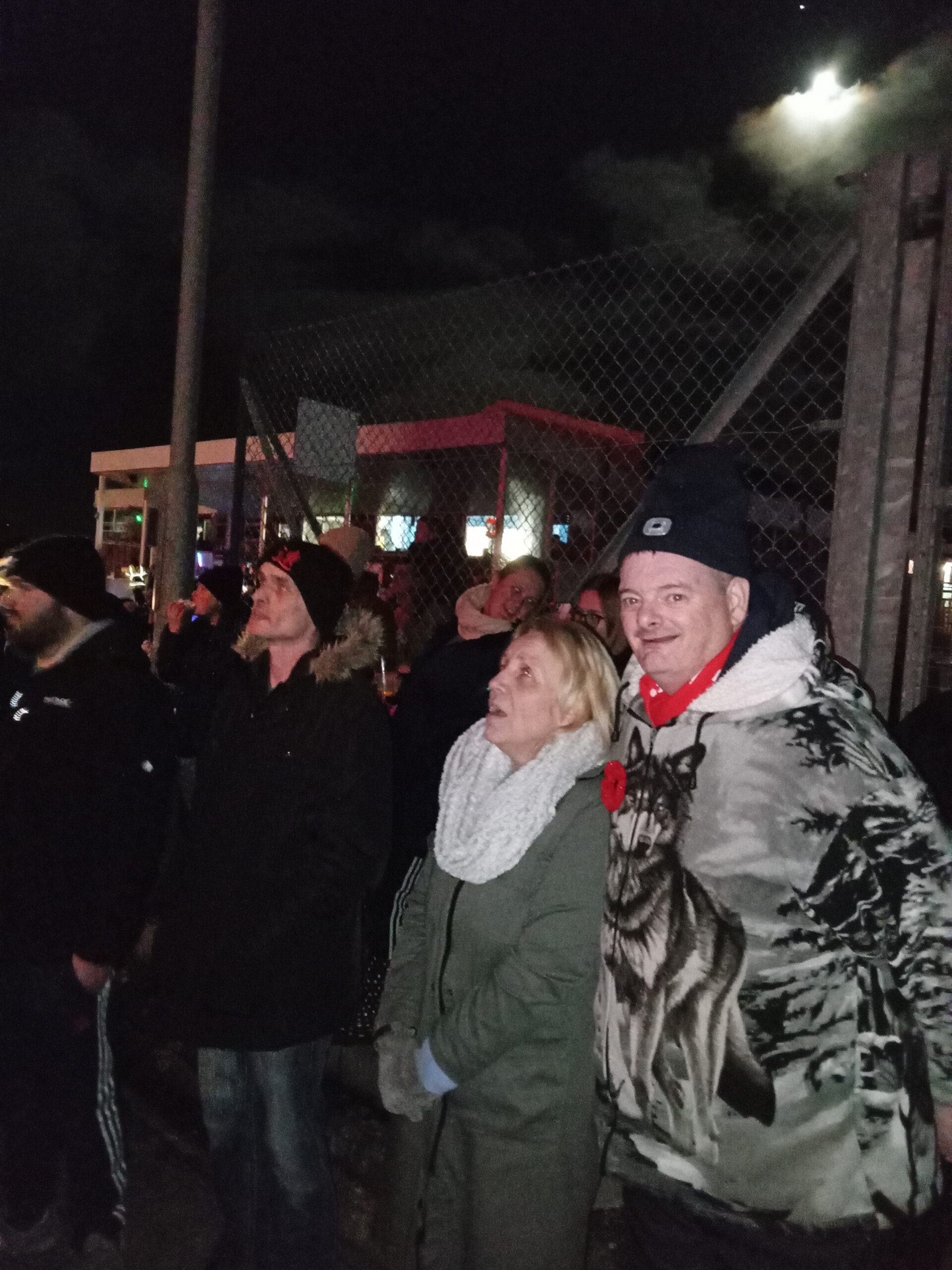 residents outdoors wrapped up warm watching fireworks