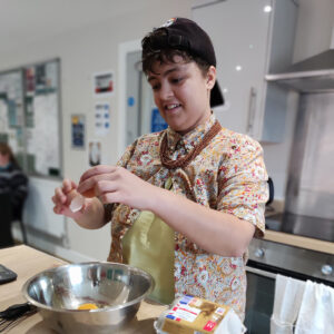 resident preparing cake mixture in bowl