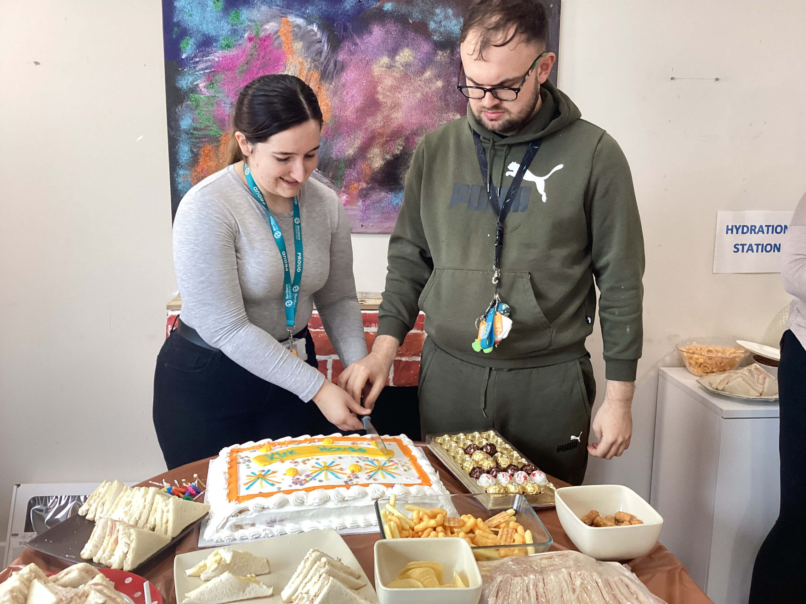 Resident and team member cutting anniversary cake