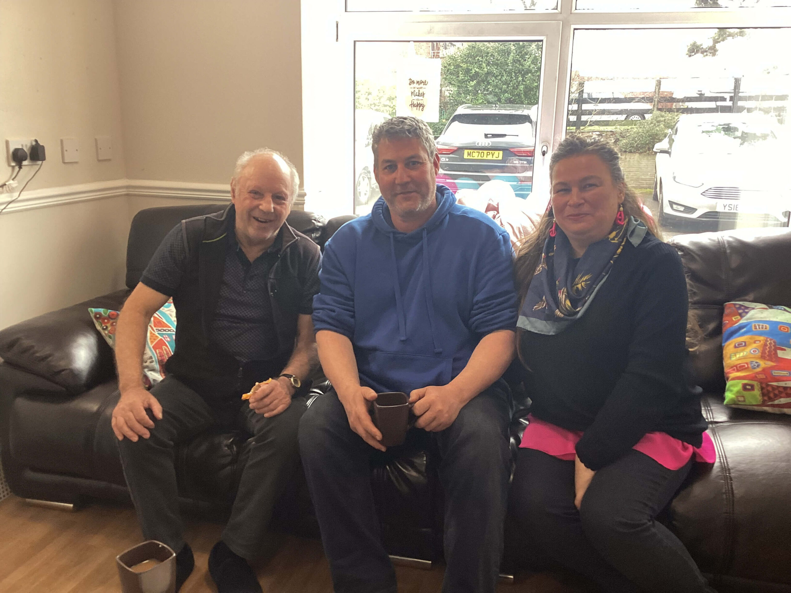 Three people sat on sofa