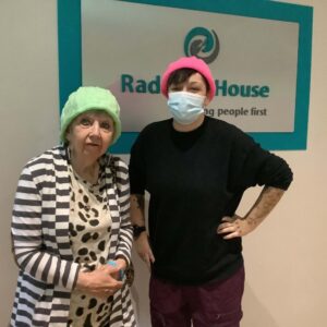 resident and team member wearing knitted hats