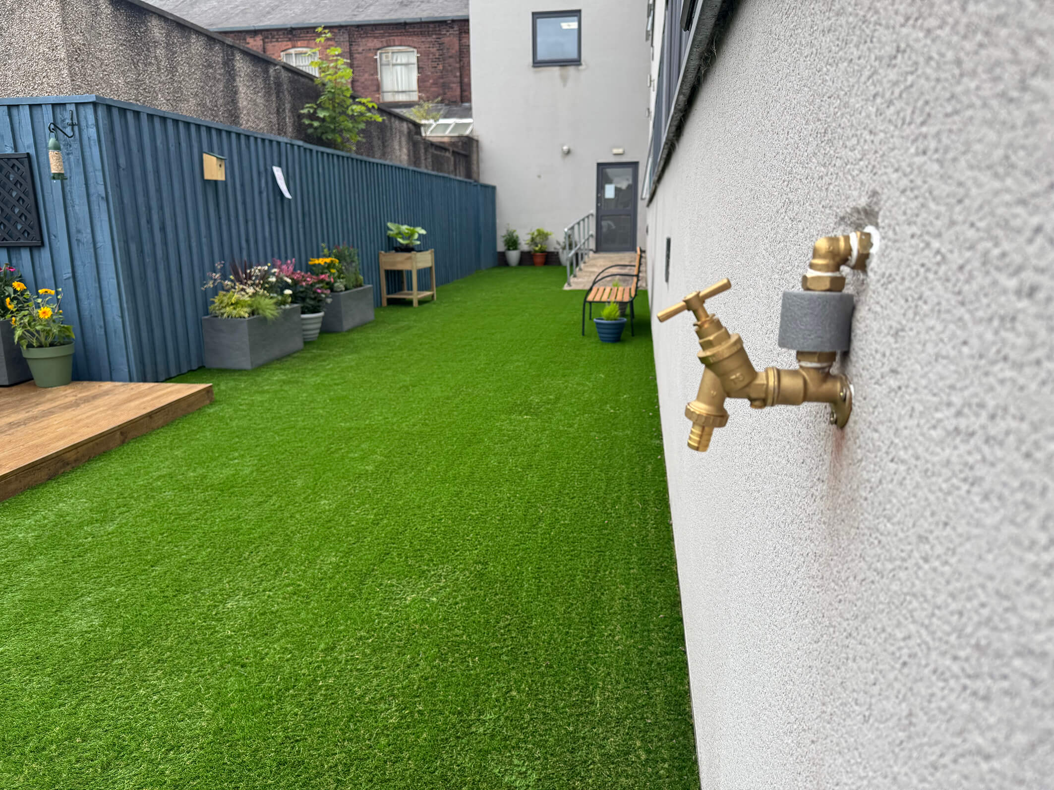 The final result of the garden makeover and renovation at Montgomery House in Bury, Greater Manchester, showing a new grassy area.