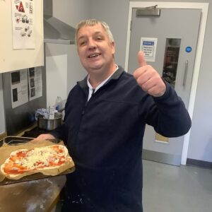 resident with thumbs up and mozzarella pizza