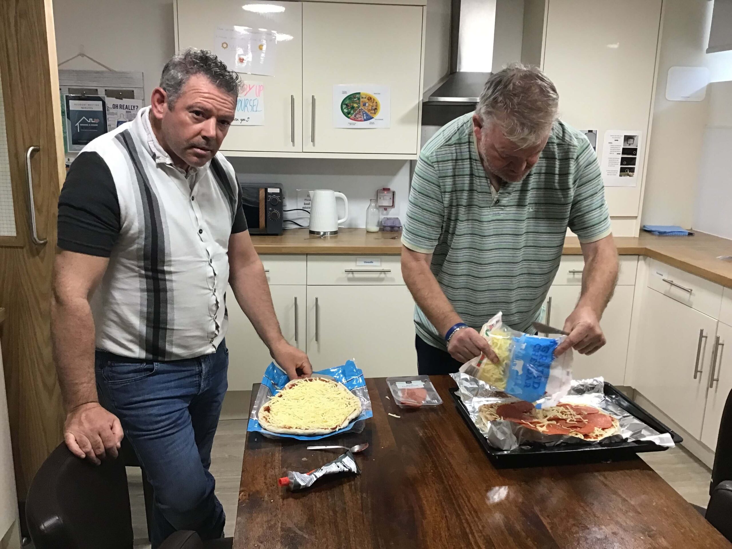 two residents making pizza