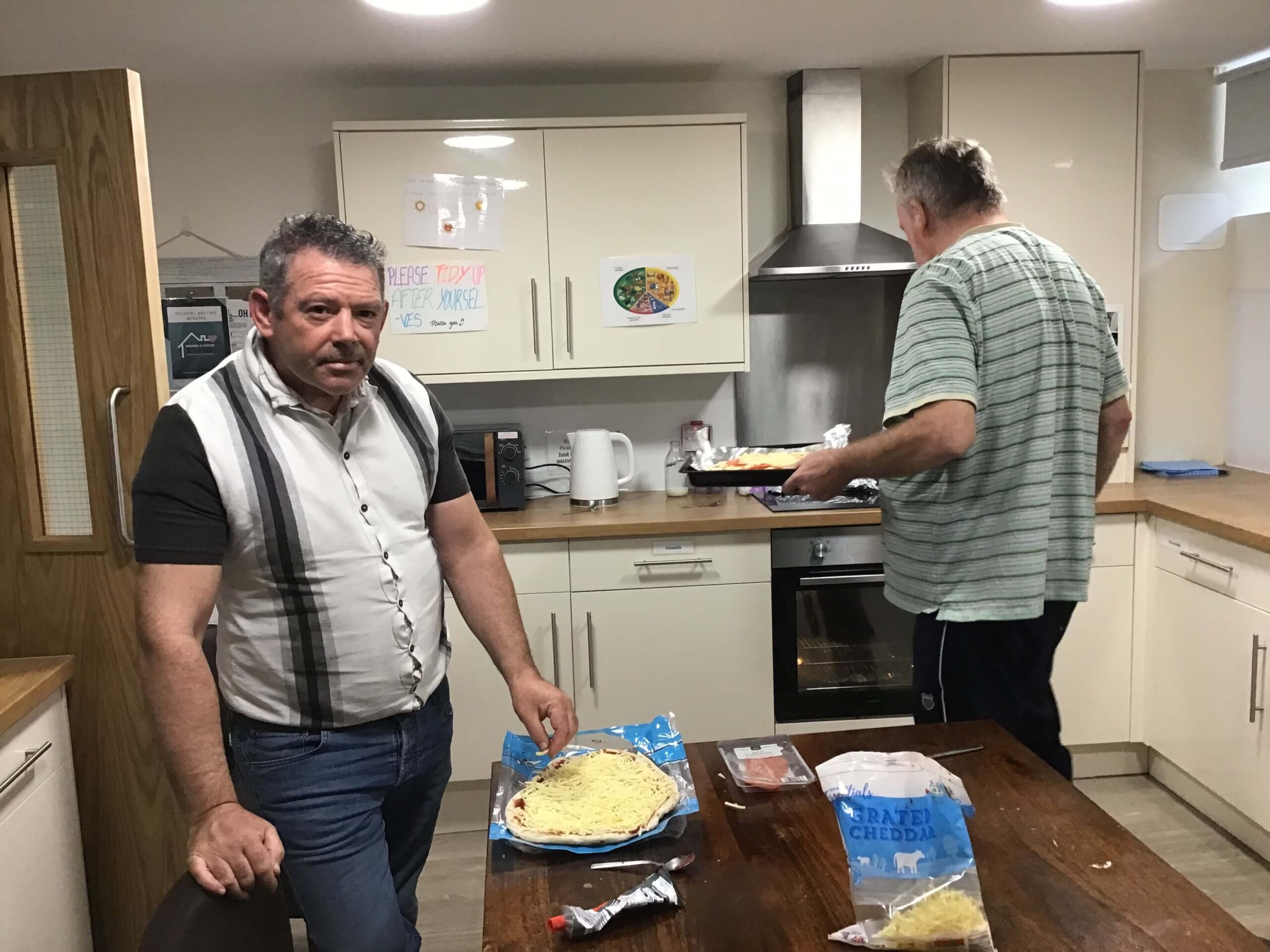 Resident putting pizza in the oven
