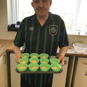 resident holding tray of cupcakes ready for the oven
