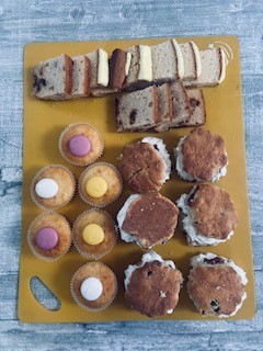 chopping board filled with a selection of cakes and scones
