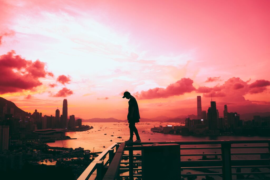 silhouette of person against red and pink sunset