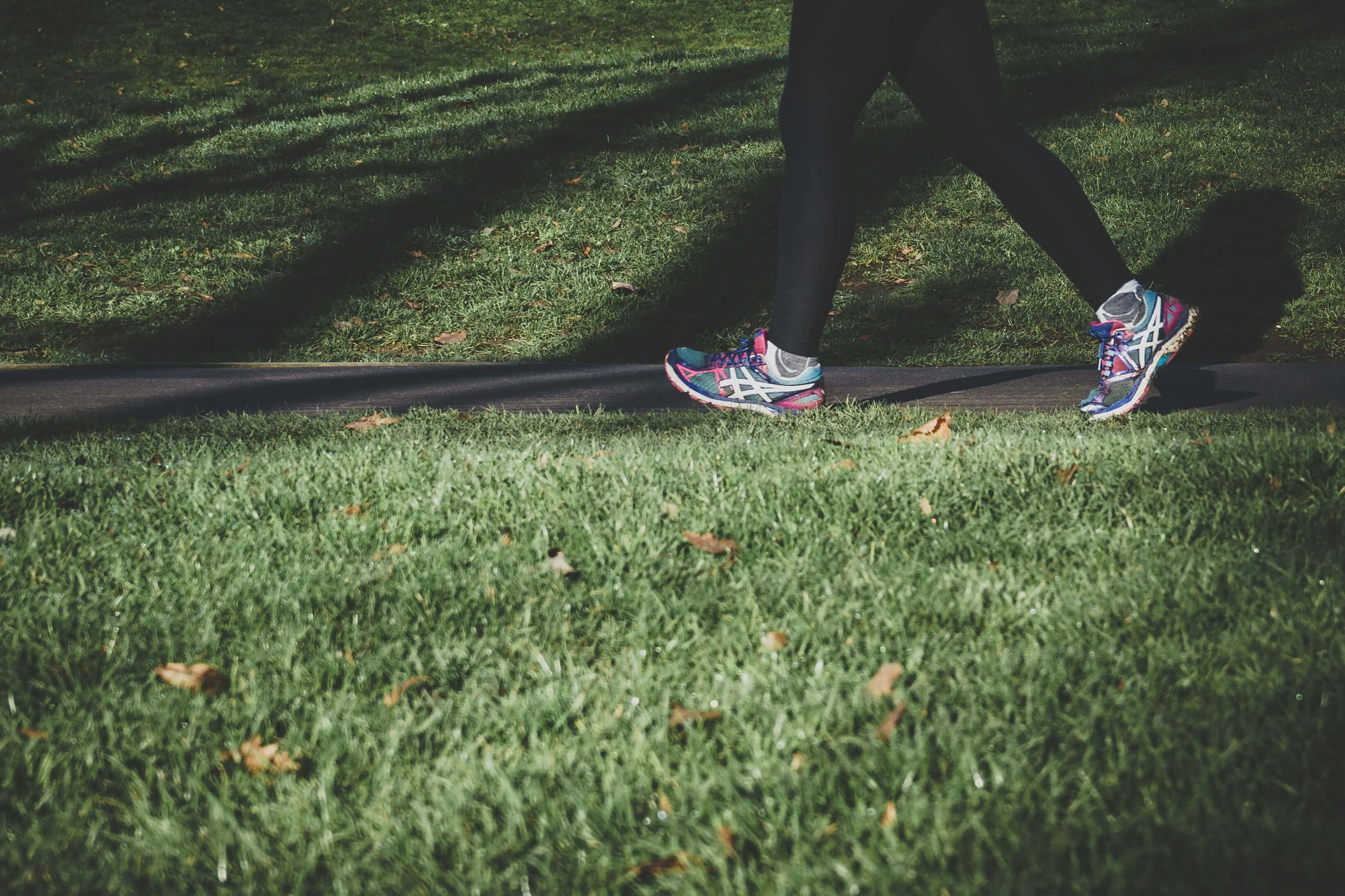A person walking and jogging through a grassy park for a post about a fundraising walk.