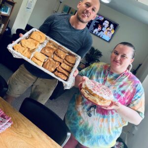 residents holding finished biscuits and cake