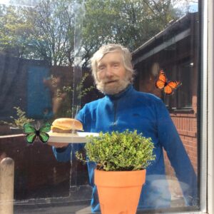 male in blue jumper holding burger