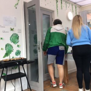 bbq and made and female with their back to camera stood by table