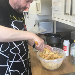 resident mixing onion bhaji mixture in bowl