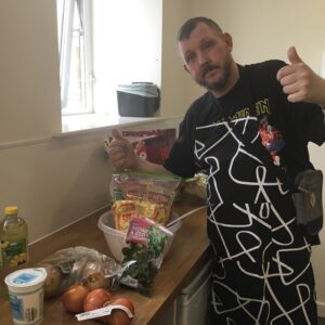 resident with thumbs up next to pile of ingredients