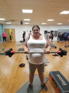 female resident at gym holding barbell