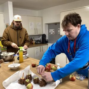 Resident putting sticks in choclate apples