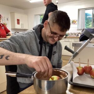 Resident dipping apples in chocolate
