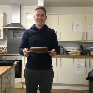 male resident holding the finished chocolate cake