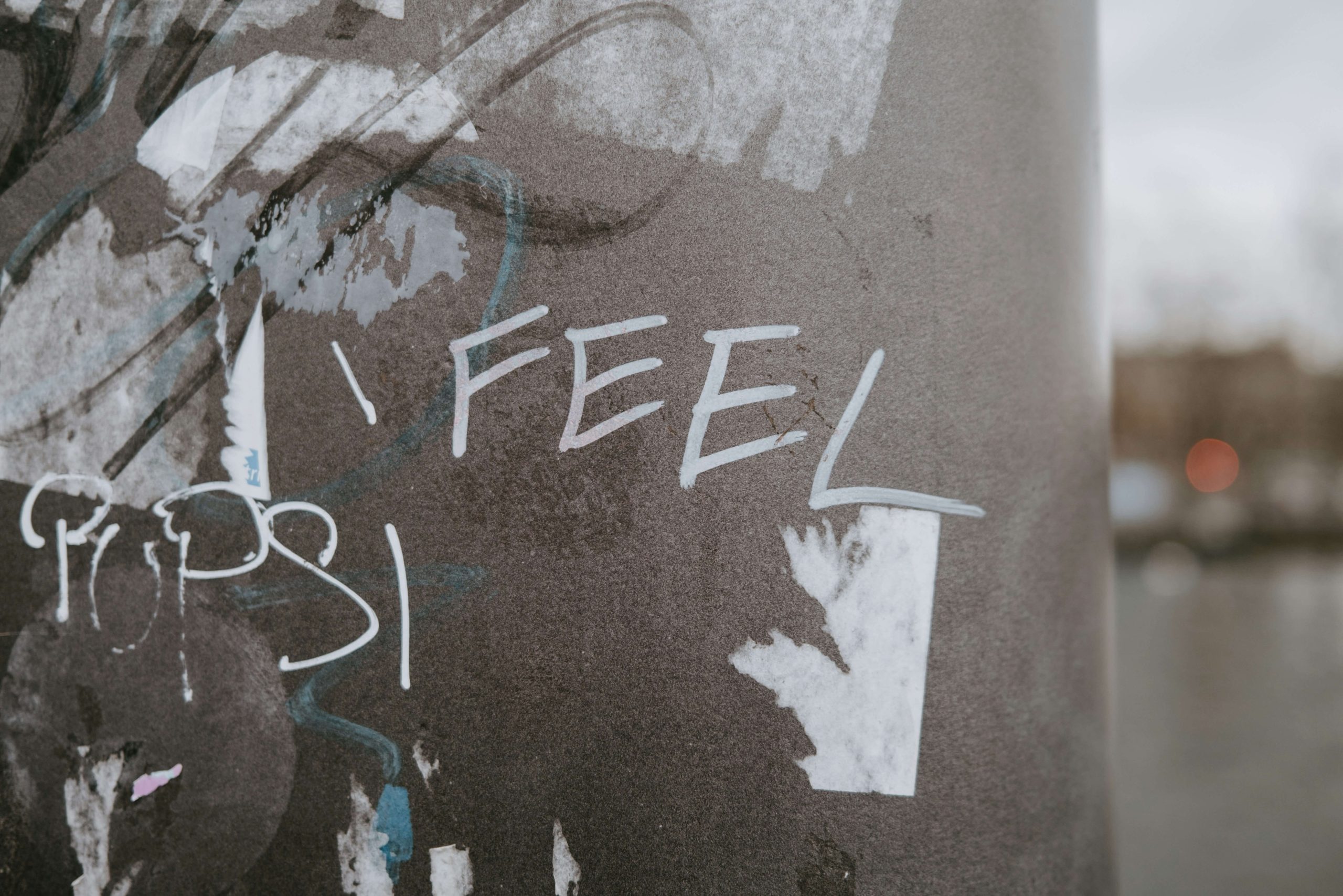 Exterior wall with graffiti saying "I feel" encouraging us to think about our feelings and emotional health.