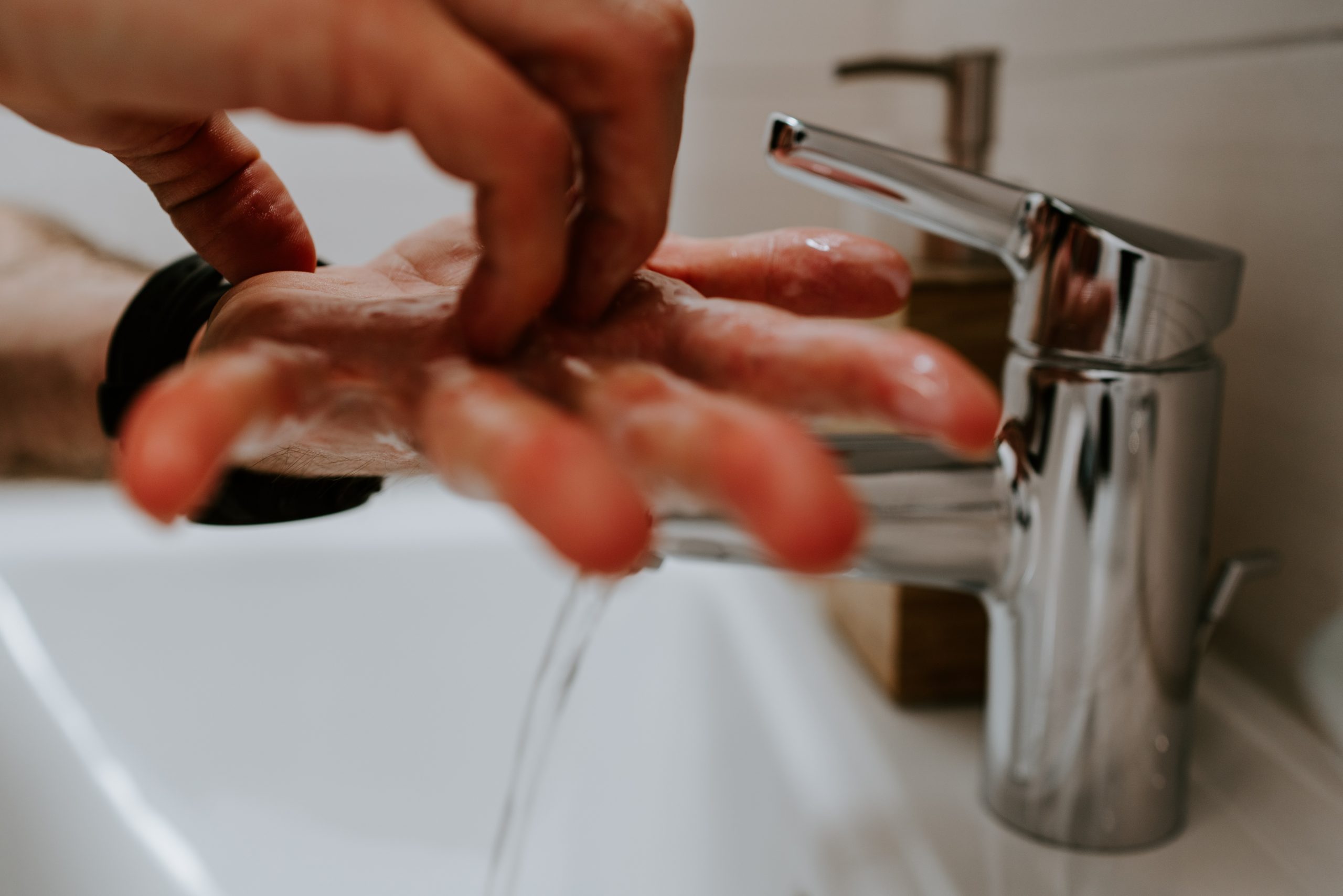 person washing hands under tap