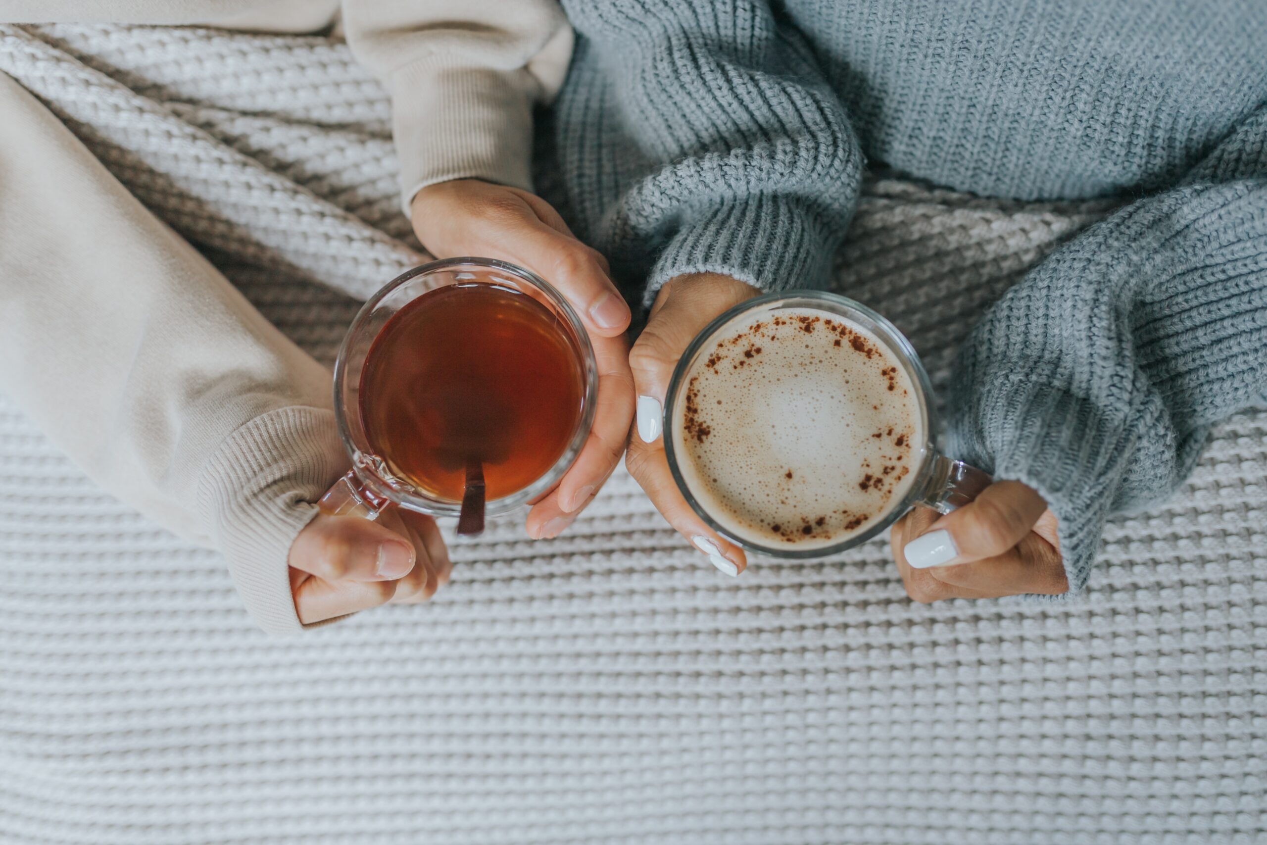 providing support: 2 people holding a cup of hot drink